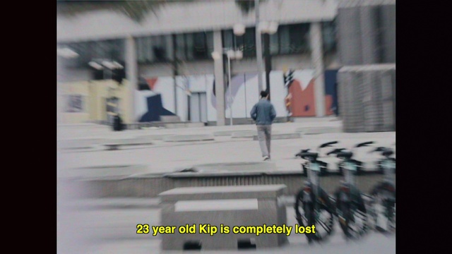 Video Reference: Wheel, Tire, Building, Vehicle, Urban design, Asphalt, Bicycle wheel, Font, Road surface, City