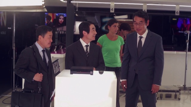 Video Reference: Coat, Gesture, Smile, Suit, Podium, Blazer, Tie, Event, White-collar worker, Stage equipment