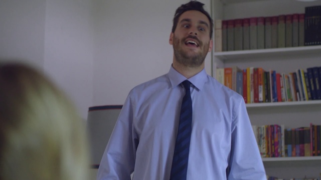 Video Reference: Bookcase, Dress shirt, Shelf, Tie, Sleeve, Smile, Gesture, Collar, Blazer, Happy