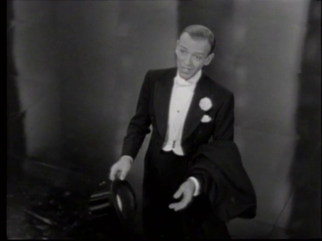 Video Reference: Suit trousers, Gesture, Flash photography, Collar, Blazer, Formal wear, Chair, Monochrome, Event, Monochrome photography