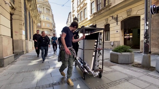 Video Reference: Footwear, Building, Window, Plant, Infrastructure, Road surface, Sky, Sidewalk, Public space, Road