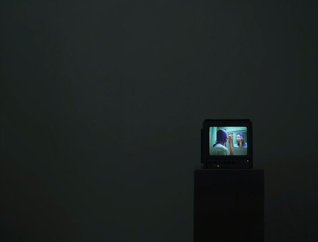 Video Reference: television, monitor, dark room, pedestal, makeup, mirror, reflection, portrait, indoor, minimalist, screen, bathroom