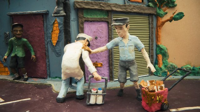 Video Reference: stop-motion, clay animation, street scene, workers, cart, buildings, figurines, urban, colorful, handmade, miniature, outdoor, animation, art