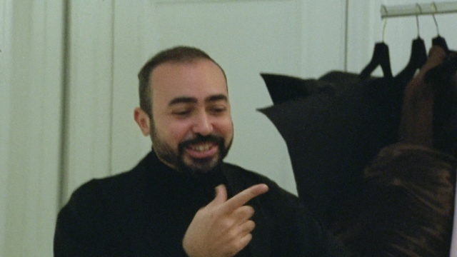 Video Reference: Outerwear, Smile, Beard, Gesture, Thumb, Event, Sign language, Thumbs signal, Moustache, Room