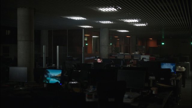Video Reference: office, workspace, computer monitors, desks, open plan, indoor, dimly lit, evening, office interior, person, ceiling lights, technology, empty office, cubicles, workstation