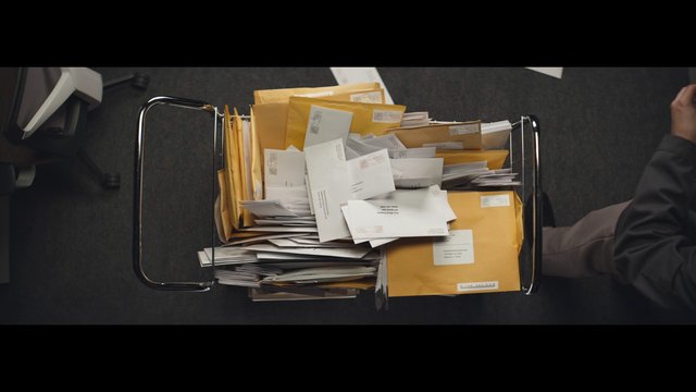 Video Reference: mail, envelopes, paperwork, office, cart, top-down, documents, stacked, postal, distribution, indoor, overhead, organization, bureaucracy, delivery, messy
