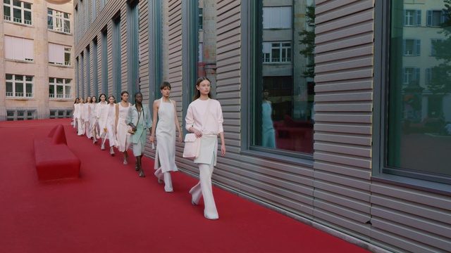 Video Reference: Window, Building, Flooring, Event, Fashion design, Uniform, Red carpet, Formal wear, Carpet, Street fashion