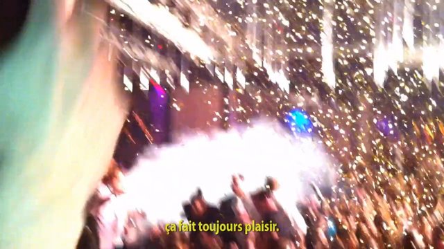 Video Reference: concert, party, crowd, confetti, stage lights, celebration, indoor event, blurry, overexposed, subtitles, performance, nightlife