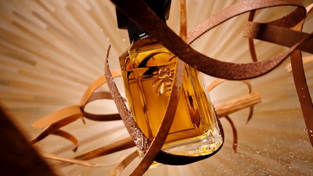 Video Reference: perfume, bottle, fragrance, cosmetic, luxury, golden, close-up, decorative, ribbons, elegant, product shot, still life, amber, beauty
