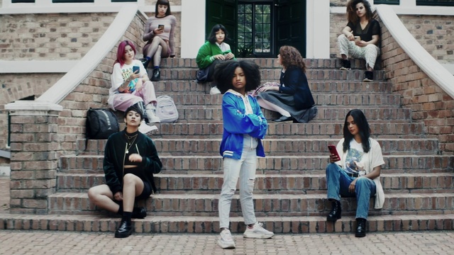 Video Reference: Clothing, Footwear, Shoe, Daytime, Green, Human, Infrastructure, Fashion, Luggage and bags, Standing