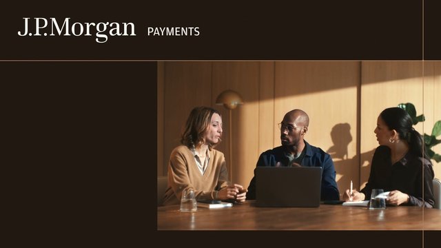 Video Reference: corporate meeting, office, laptop, three people, conference table, business discussion, warm lighting, wooden interior, notebook, glass cups, presentation, finance, payments, teamwork, indoor, J.P. Morgan
