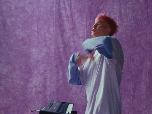 Video Reference: Purple, Microphone, Human body, Flash photography, Audio equipment, Artist, Entertainment, Magenta, Performing arts, Elbow