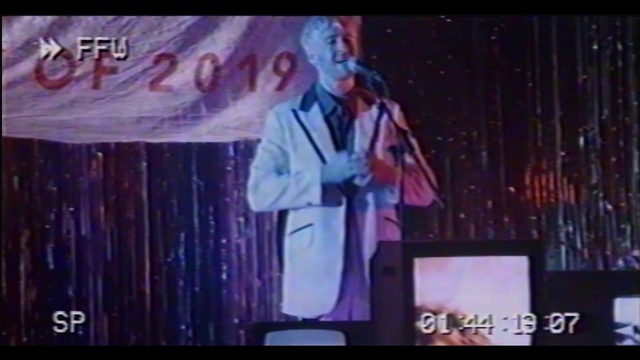 Video Reference: Coat, Tie, Entertainment, Music artist, Television program, Performing arts, Font, Event, Display device, Music