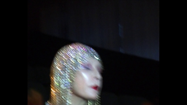 Video Reference: Eyelash, Flash photography, Entertainment, Fashion design, Event, Darkness, Electric blue, Glass, Fashion accessory, Headpiece