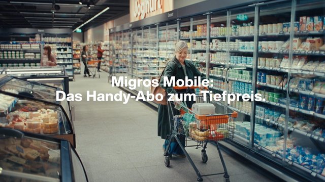 Video Reference: supermarket, grocery store, shopping cart, aisle, refrigerated cases, dairy products, woman, shoppers, retail, indoor, advertisement, German text, consumer goods, food display