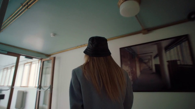 Video Reference: Hat, Sleeve, Sun hat, Wood, Wall, Tints and shades, Shade, Ceiling, Street fashion, Room