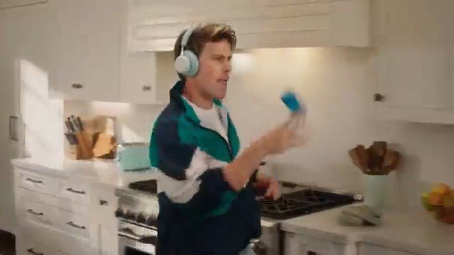 Video Reference: kitchen, person, headphones, indoor, cooking, modern home, standing, stove, countertop, motion blur, lifestyle, casual, home interior