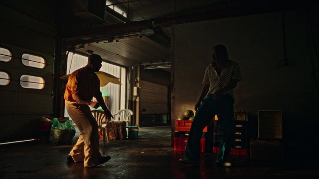 Video Reference: garage, warehouse, silhouette, two people, doorway, backlit, low light, indoor, industrial, shadows, concrete floor, crate, chairs, daylight, moody, interior