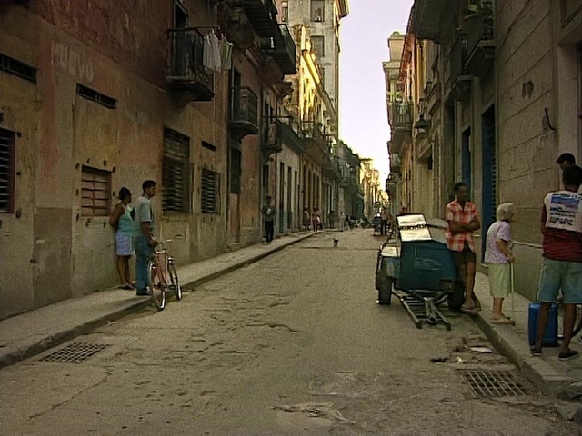 Video Reference: Footwear, Tire, Wheel, Building, Road surface, Infrastructure, Sky, Asphalt, Mode of transport, Thoroughfare