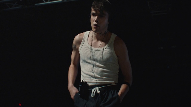 Video Reference: Flash photography, Undershirt, Vest, Elbow, Performing arts, T-shirt, Entertainment, Chest, Event, Belt