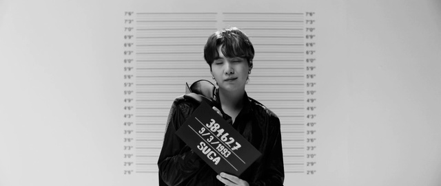 Video Reference: Flash photography, Neck, Sleeve, Gesture, Street fashion, Font, Black hair, Eyewear, Audio equipment, Fashion design