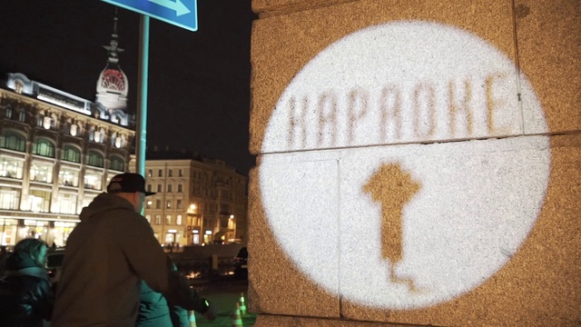 Video Reference: Lighting, Building, Road surface, Wood, Public space, Font, Art, Tints and shades, Circle, City