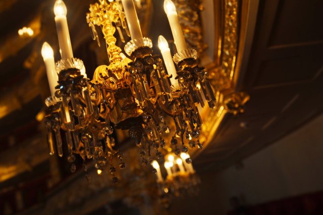 Video Reference: chandelier, crystal, gold, ornate, interior, lighting, candle bulbs, luxury, decor, warm light, ceiling, classic, elegant, glamour