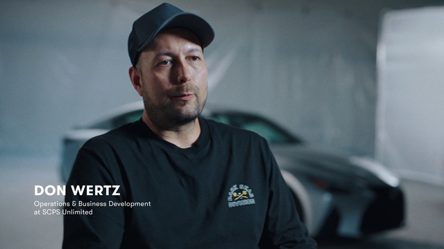 Video Reference: Forehead, Face, Beard, Flash photography, Sleeve, Cap, T-shirt, Facial hair, Automotive design, Electric blue