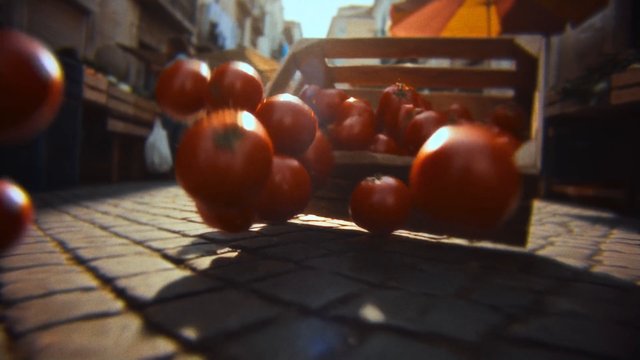 Video Reference: tomatoes, street, market, produce, cobblestone, crate, bouncing, motion, low angle, outdoor, sunlight, food, fresh, urban, daylight
