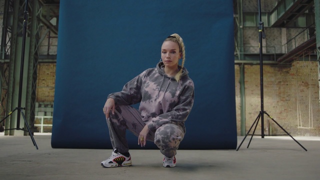 Video Reference: Street fashion, Performing arts, Entertainment, Asphalt, Flooring, Event, Electric blue, Knee, Road surface, Fashion design