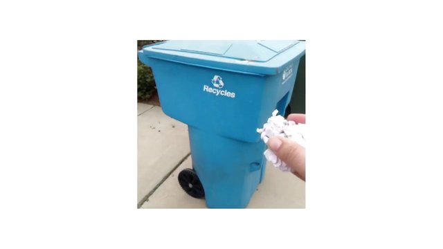 Video Reference: recycling, recycle bin, trash bin, paper, paper waste, hand, sidewalk, outdoor, waste disposal, blue bin, municipal, curbside, household recycling