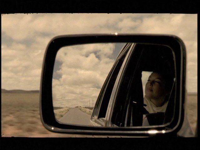 Video Reference: car, side mirror, rear view, road, travel, landscape, cloudy sky, vehicle, passenger, desert, open road, reflection, outdoors