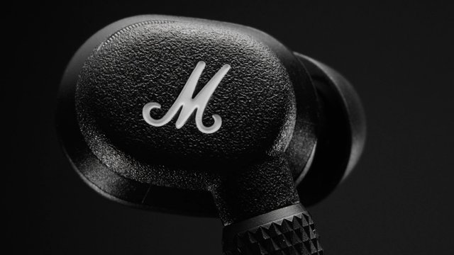 Video Reference: earbud, wireless earbud, headphones, audio device, close-up, black, logo, product shot, electronics, tech, isolated, dark background