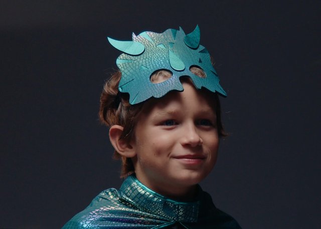 Video Reference: child, costume, mask, theater, play, dress-up, blue, portrait, studio, dark background, fantasy, imagination, smiling, festival, performance