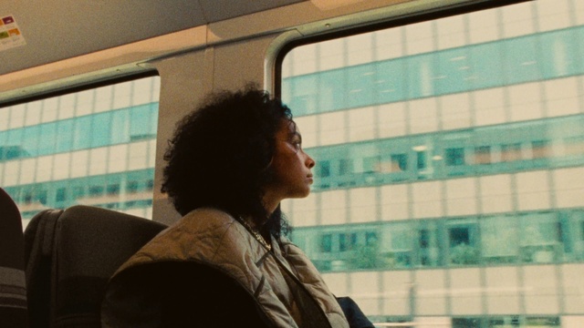 Video Reference: Window, Tints and shades, Glass, Public transport, White-collar worker, Sitting, Room, Eyewear, City, Reflection