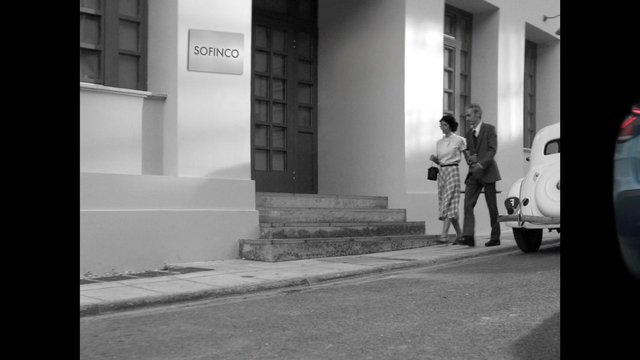 Video Reference: black and white, street, building, entrance, stairs, sidewalk, parked car, couple, walking, urban, vintage, architecture