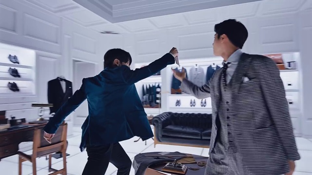 Video Reference: Trousers, Coat, Gesture, Table, Fashion design, Baseball cap, White-collar worker, Event, Eyewear, Engineering