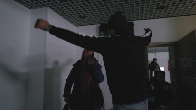 Video Reference: Outerwear, Sleeve, Gesture, T-shirt, Event, Fun, Entertainment, Darkness, Audio equipment, Performing arts