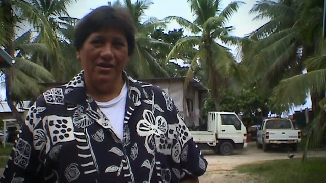 Video Reference: woman, outdoors, palm trees, tropical, village, house, truck, portrait, daylight, rural, road, standing, trees, vehicle, nature, travel
