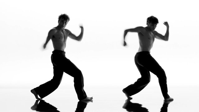 Video Reference: dancer, male, shirtless, motion, pose, studio, white background, black and white, reflection, performance, dance, athletic, minimal, silhouette