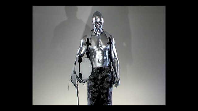 Video Reference: Outerwear, Arm, Shoulder, Flash photography, Sleeve, Gesture, Headgear, Personal protective equipment, Fictional character, Font