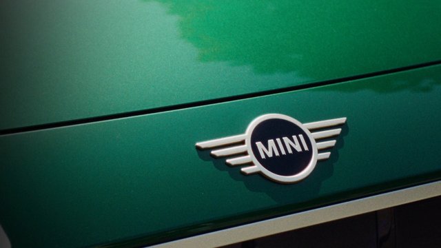 Video Reference: car, automobile, badge, emblem, logo, MINI, close-up, green, vehicle, fender, branding, metal, detail, transportation