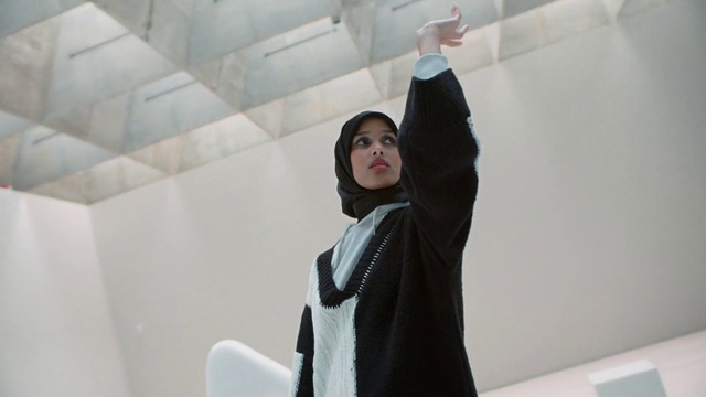 Video Reference: Sleeve, Gesture, Fashion design, Event, Eyewear, Stairs, Elbow, Room, Sign language, Waist