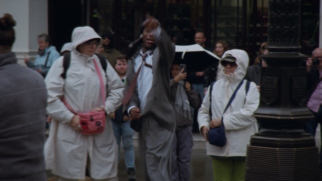 Video Reference: Gesture, Hat, Event, Sun hat, Crowd, Pedestrian, Road, Uniform, City, Street