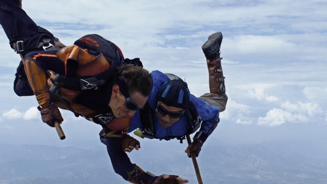 Video Reference: Tandem skydiving, Sky, Cloud, Helmet, Glove, Sports equipment, Parachuting, Travel, Leisure, Stunt performer