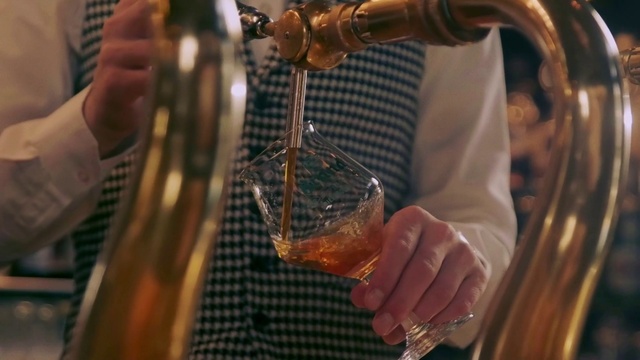 Video Reference: Hand, Drinkware, Cognac, Amber, Barware, Drink, Stemware, Alcoholic beverage, Tableware, Glass bottle