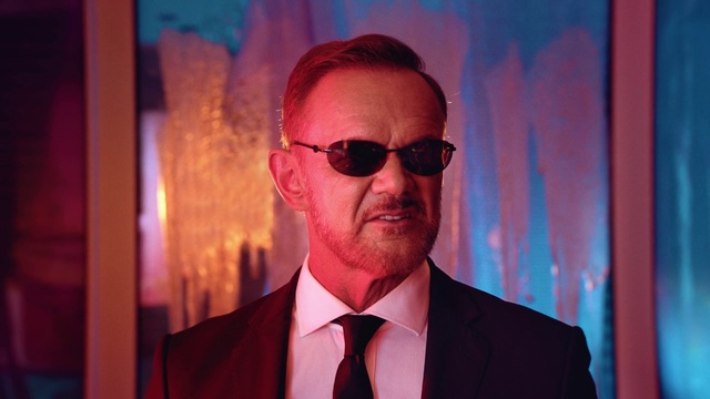 Video Reference: Forehead, Glasses, Chin, Vision care, Sunglasses, Purple, Eyewear, Flash photography, Dress shirt, Pink