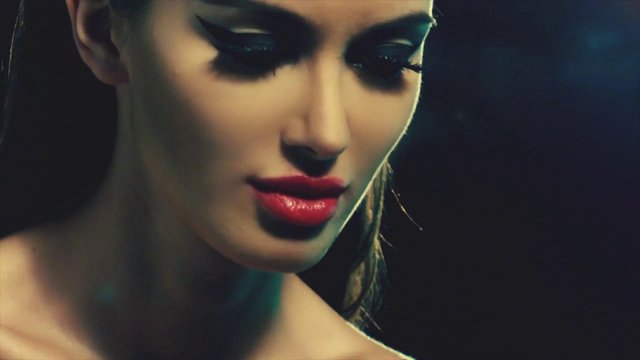 Video Reference: portrait, close-up, woman, makeup, red lips, fashion, beauty, dramatic lighting, studio, face, model, dark background
