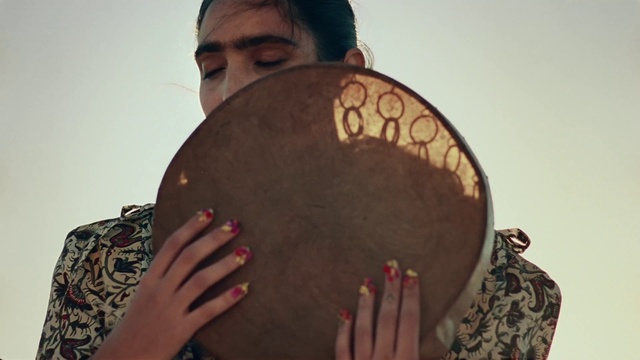 Video Reference: Head, Membranophone, Hand, Drum, Musical instrument, Sky, Idiophone, Gesture, Black hair, Eyewear