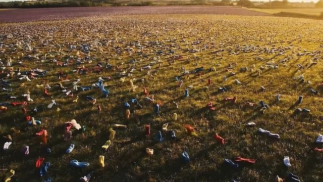 Video Reference: field, grass, socks, scattered, aerial, sunset, landscape, outdoors, colorful, texture, installation, wide shot, golden hour
